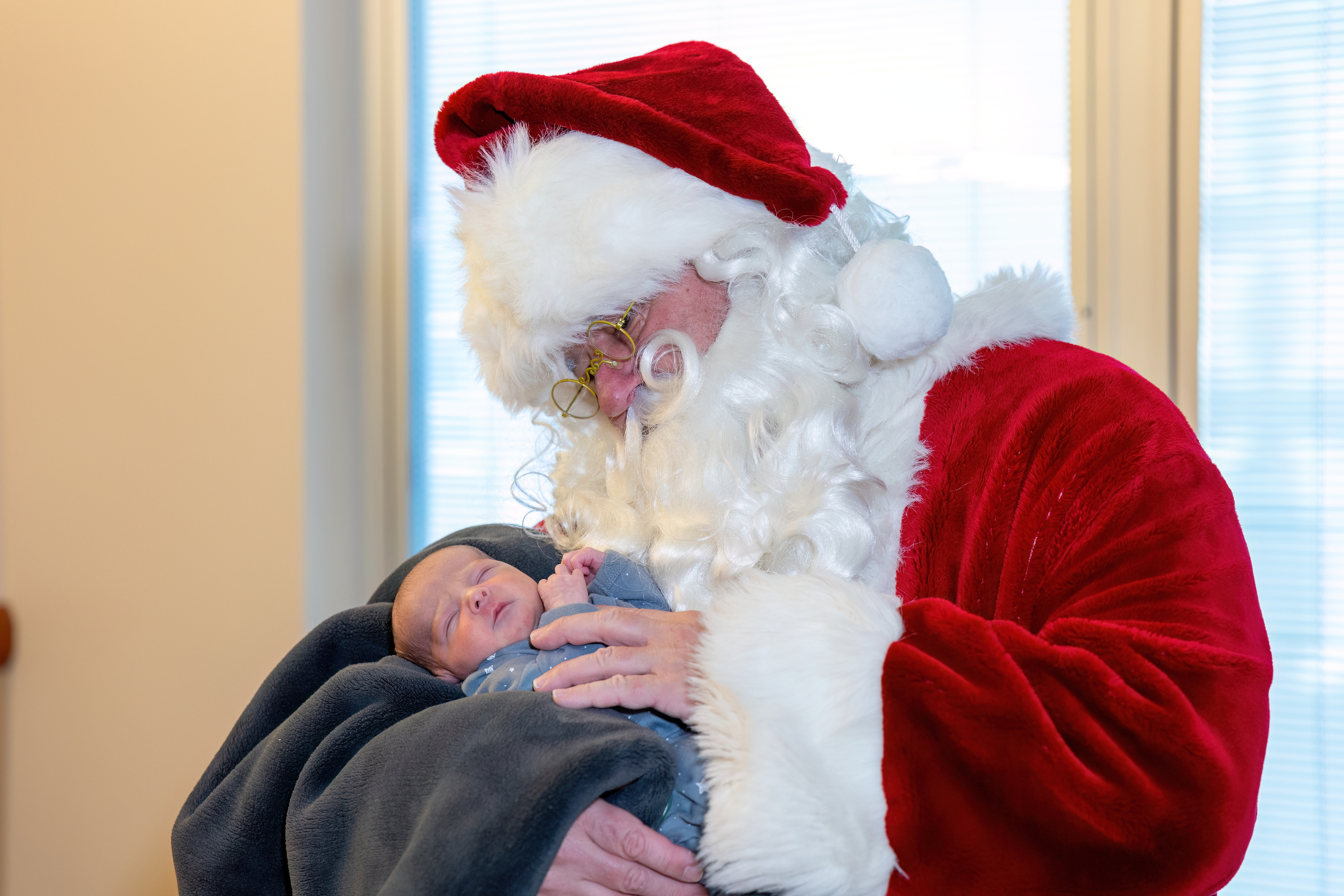 Centerpoint NICU baby rests gently in Santa's arms.