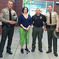 Dora Pennington smiles while standing with the emergency first responders that helped her after a dog attack.