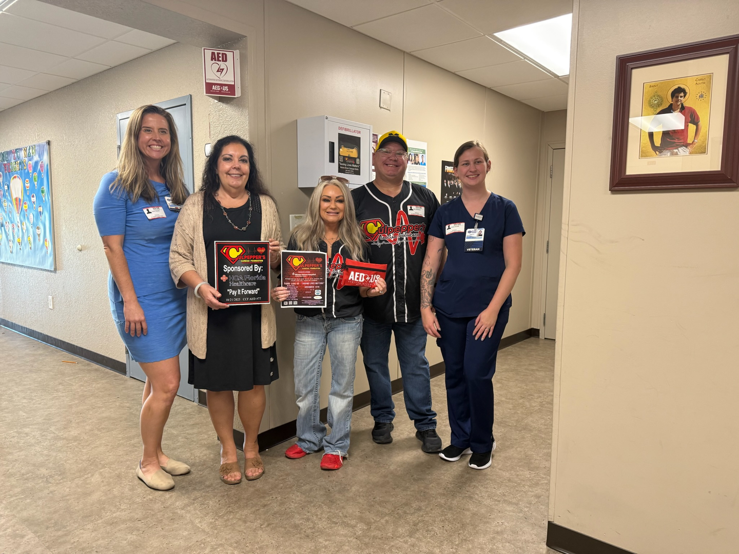 Foundation members, hospital team and school administrative team pose with the new AED.