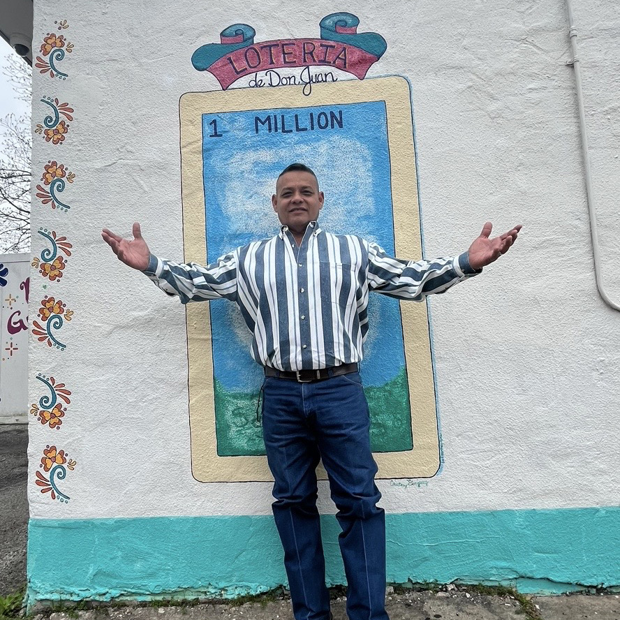 Arthur Guzman post transplant posing with in front of some wall art.