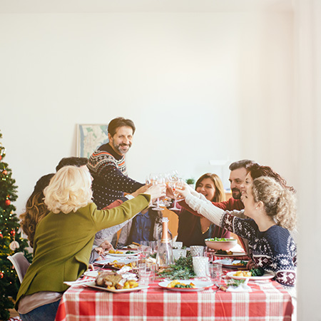 A family at a holiday dinner table raising their glasses