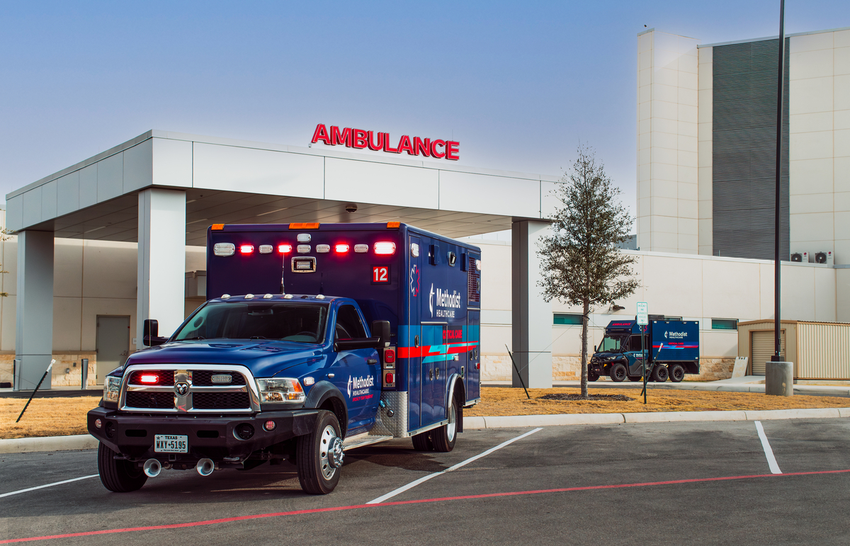 Blue critical care ambulance from the Methodist Healthcare Critical Care and Specialty Teams parked outside a medical facility.