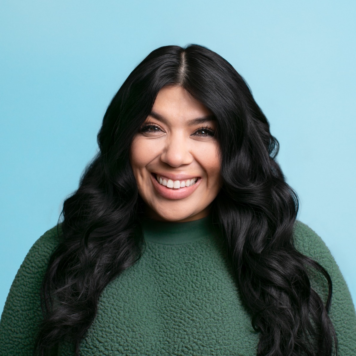 Joanna Rosa Saenz wearing glasses and a green sweater.