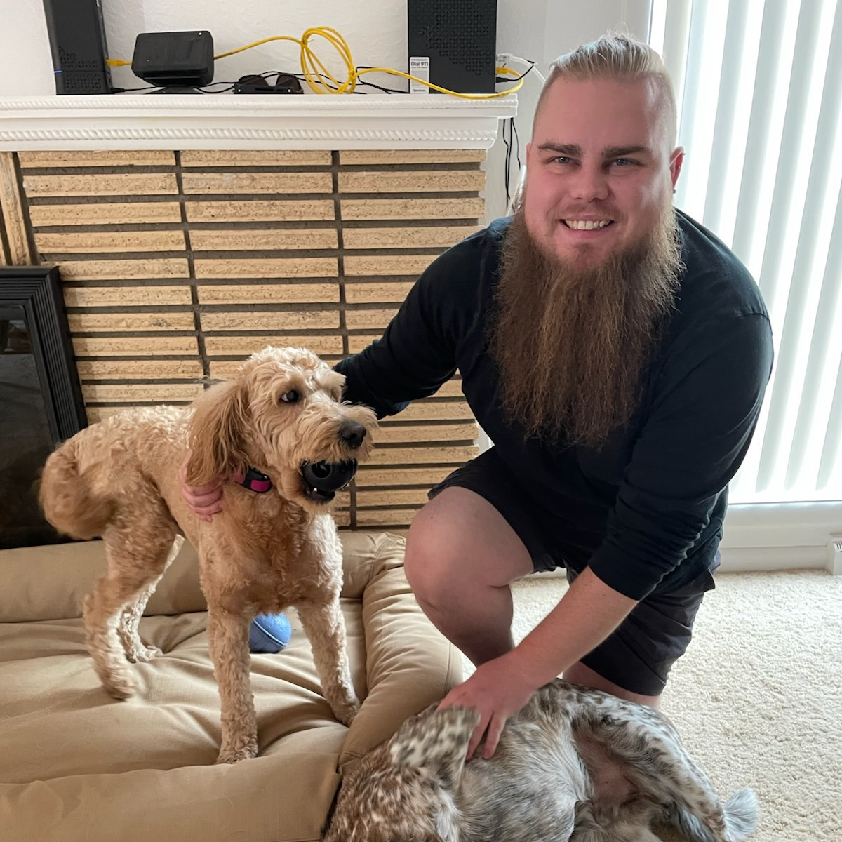 Parker smiles at camera with his two dogs.
