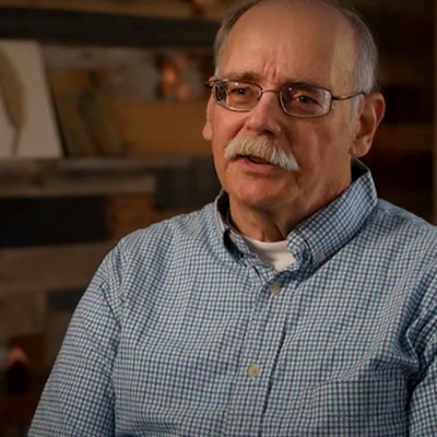 Bruce wearing glasses and a checkered button up shirt.