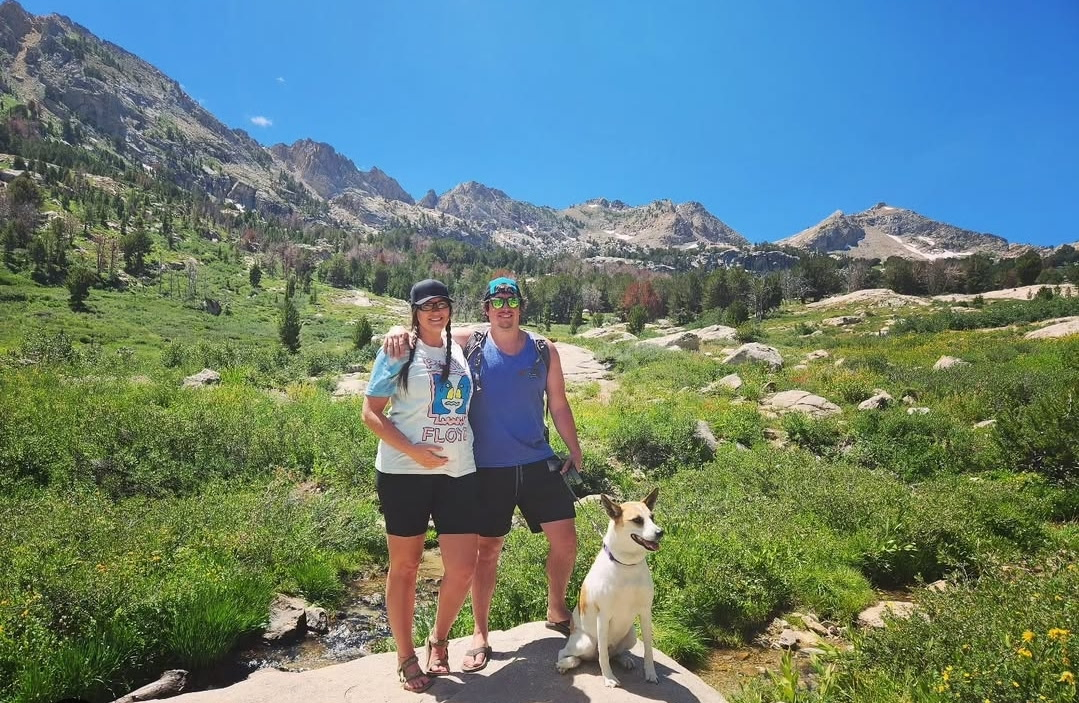 Ashley, her husband, and dog hiking in the mountains