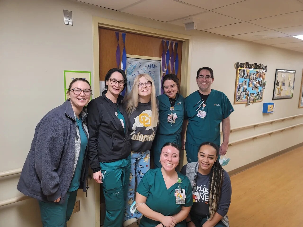 Anna and her care team smiling and posing for photograph in the hall of the hospital.