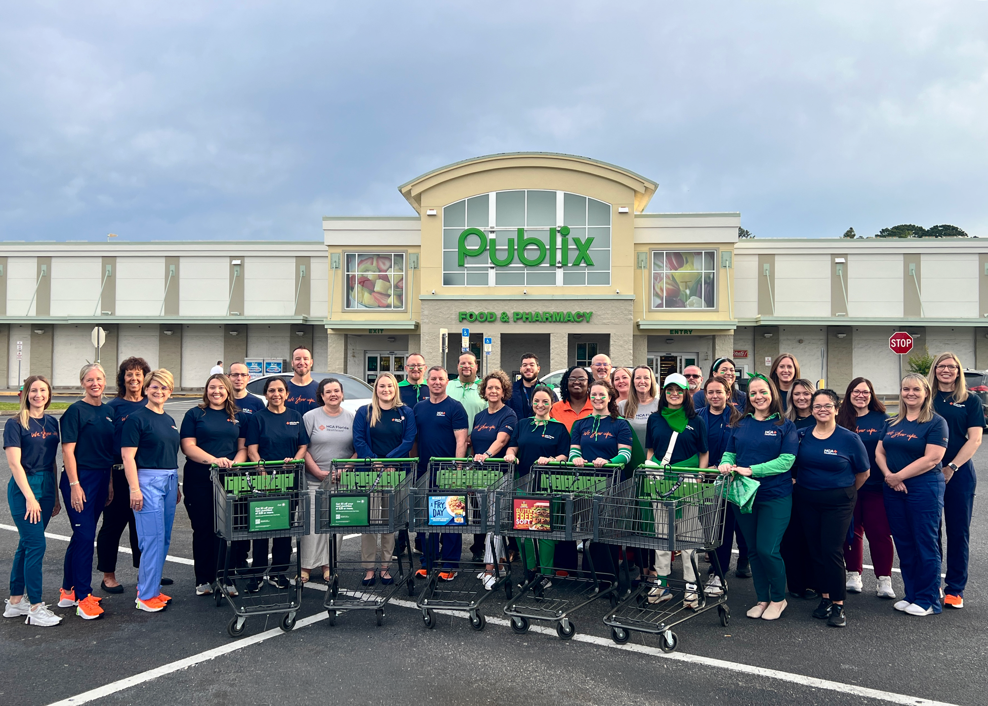 Over 30 people gather around shopping carts in the parking lot of Publix Super Market