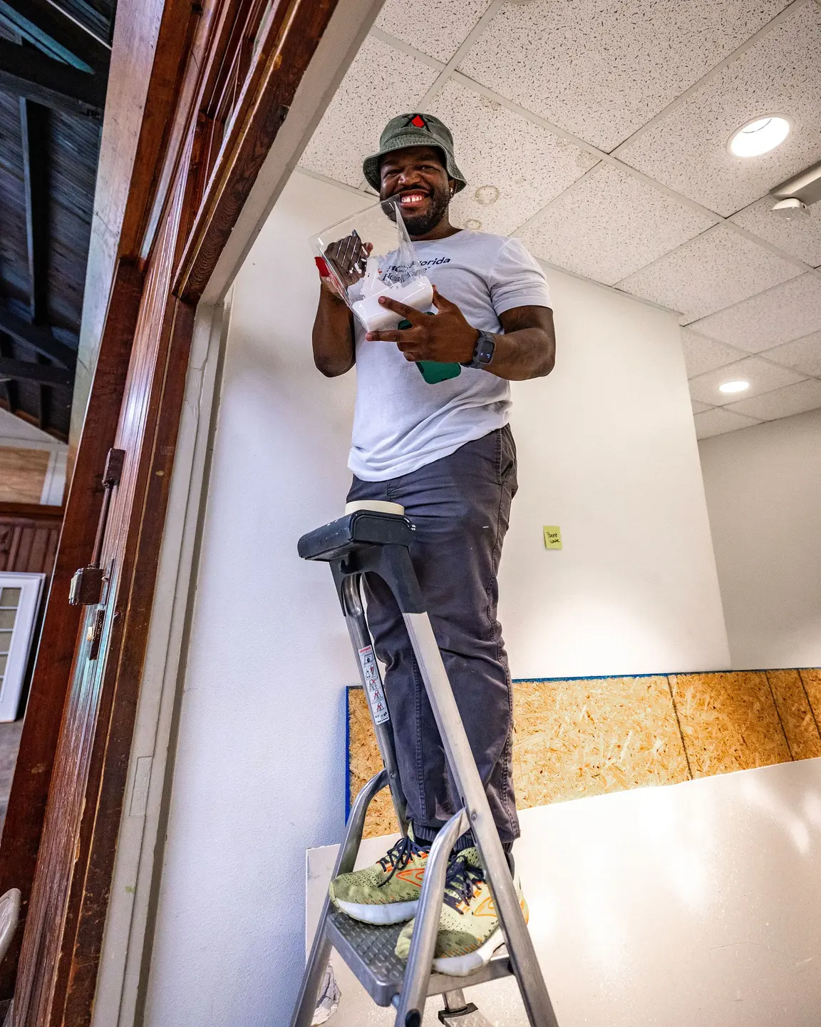 HCA Volunteer on a ladder.