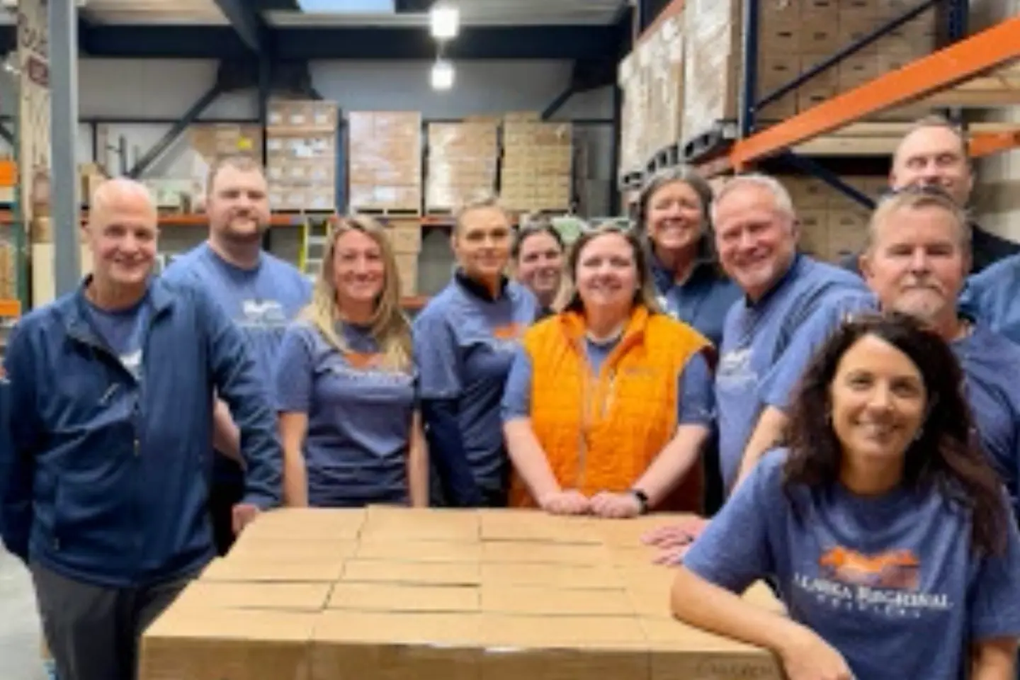 West Valley Medical Center employees smile while sitting together in a warehouse during a volunteer event.
