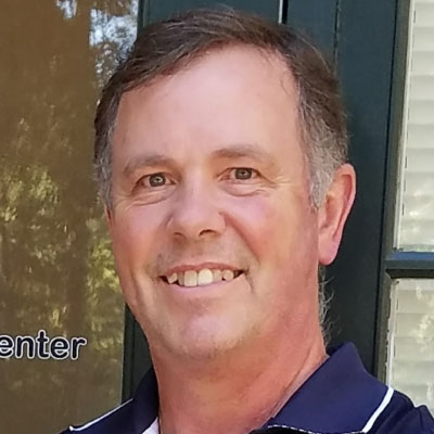 Dennis Ittenback smiles while wearing a blue polo shirt.