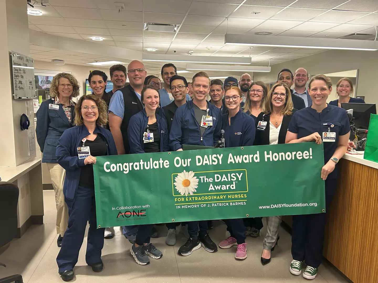 Daisy Award winner Michael Sulpizio, pictured with co-workers and the  Congratulate-a-Daisy-Award-Winner banner.