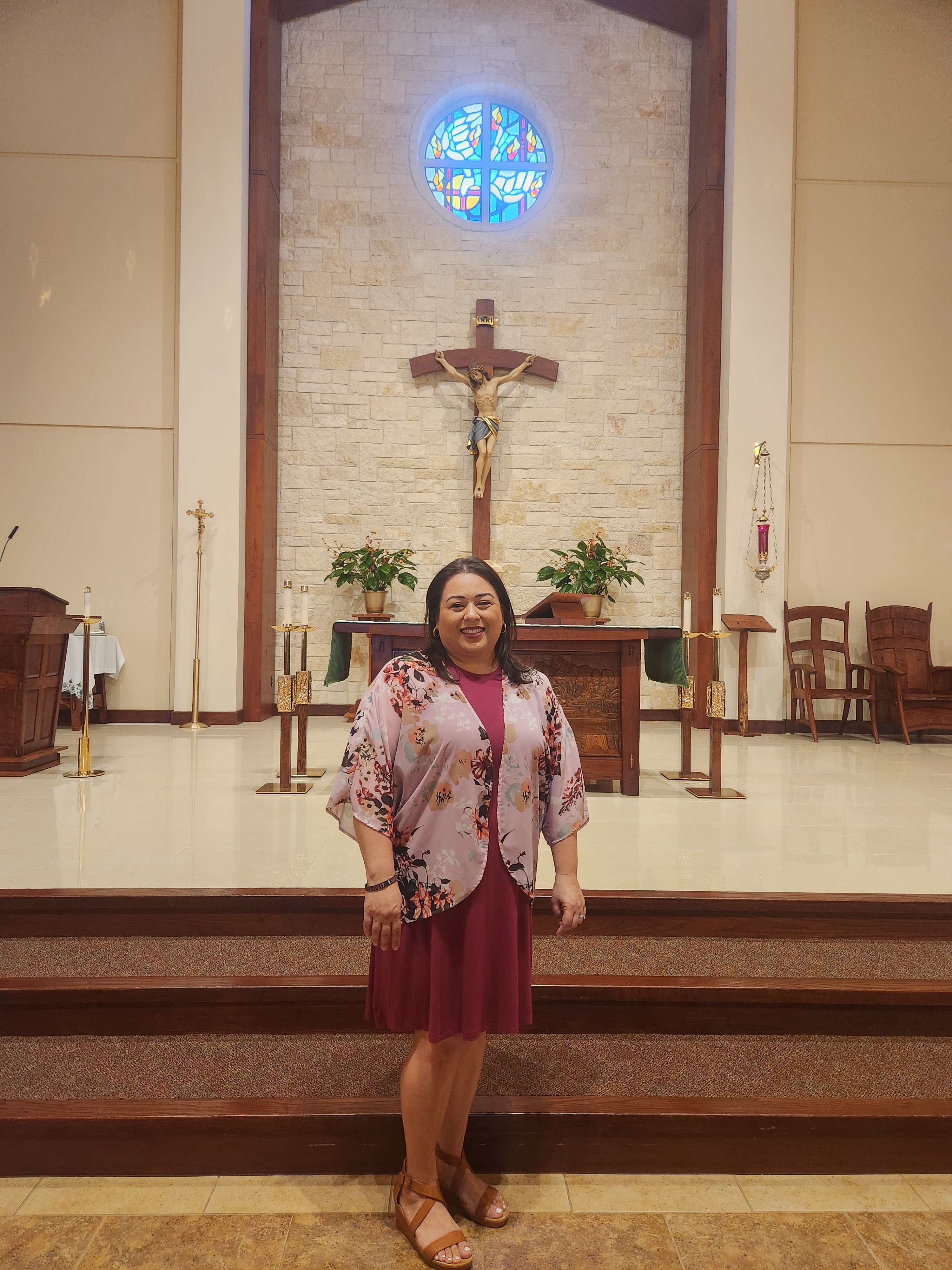 Marisol Lopez standing in front of a cross at St. Jerome Catholic Church.