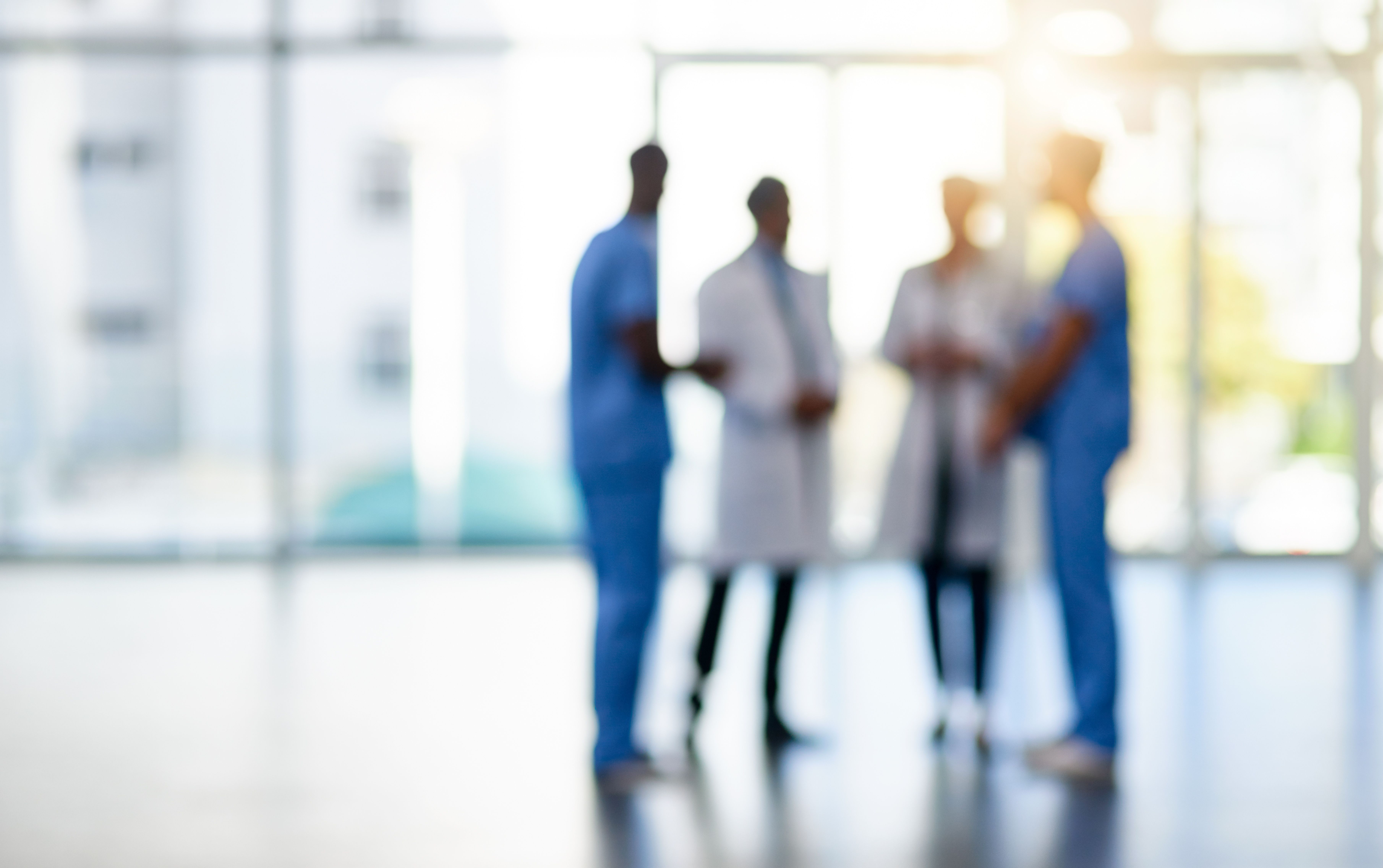 A blurred shot of medical staff members standing together in a hospital.