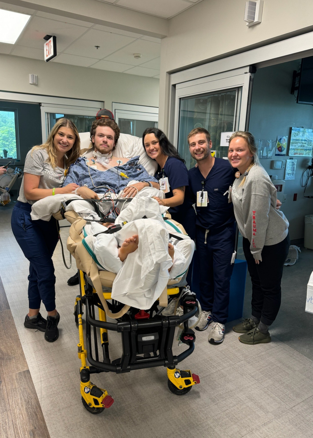 Bo Bryant with his trauma ICU team surrounding him while he is on a transport stretcher