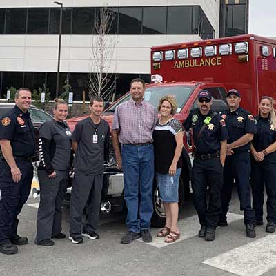 Jeannette McFarland and her husband, Darin, smile while standing with the first responder team at Brigham City Community Hospital.