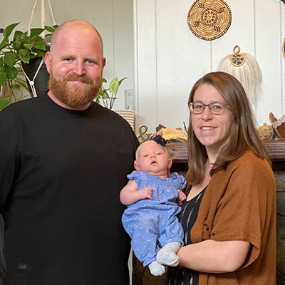 Caleb and Danielle Curry pose with their newborn baby Hazel.