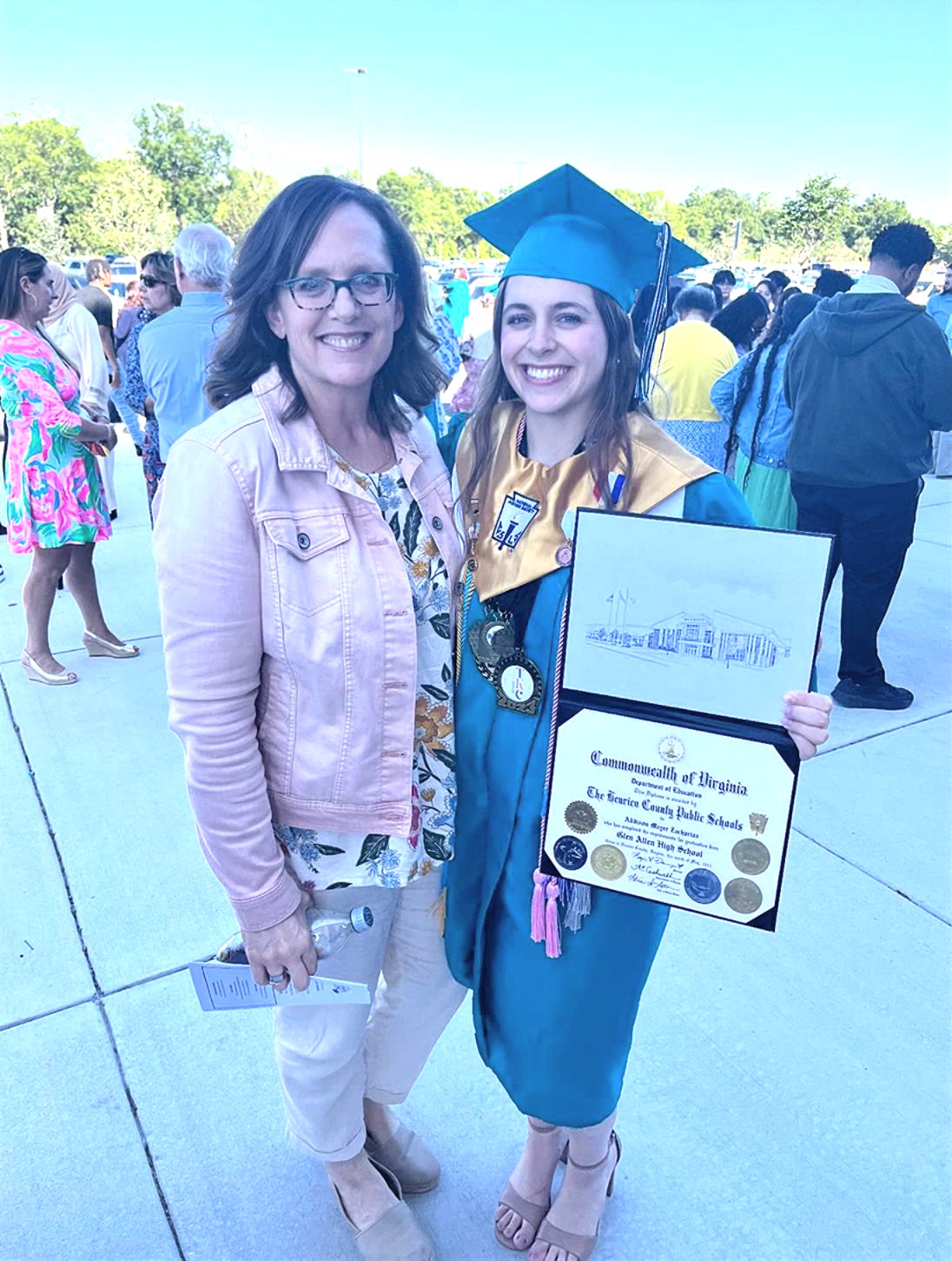 Addison with Melissa Zacharias after graduation in cap and gown.