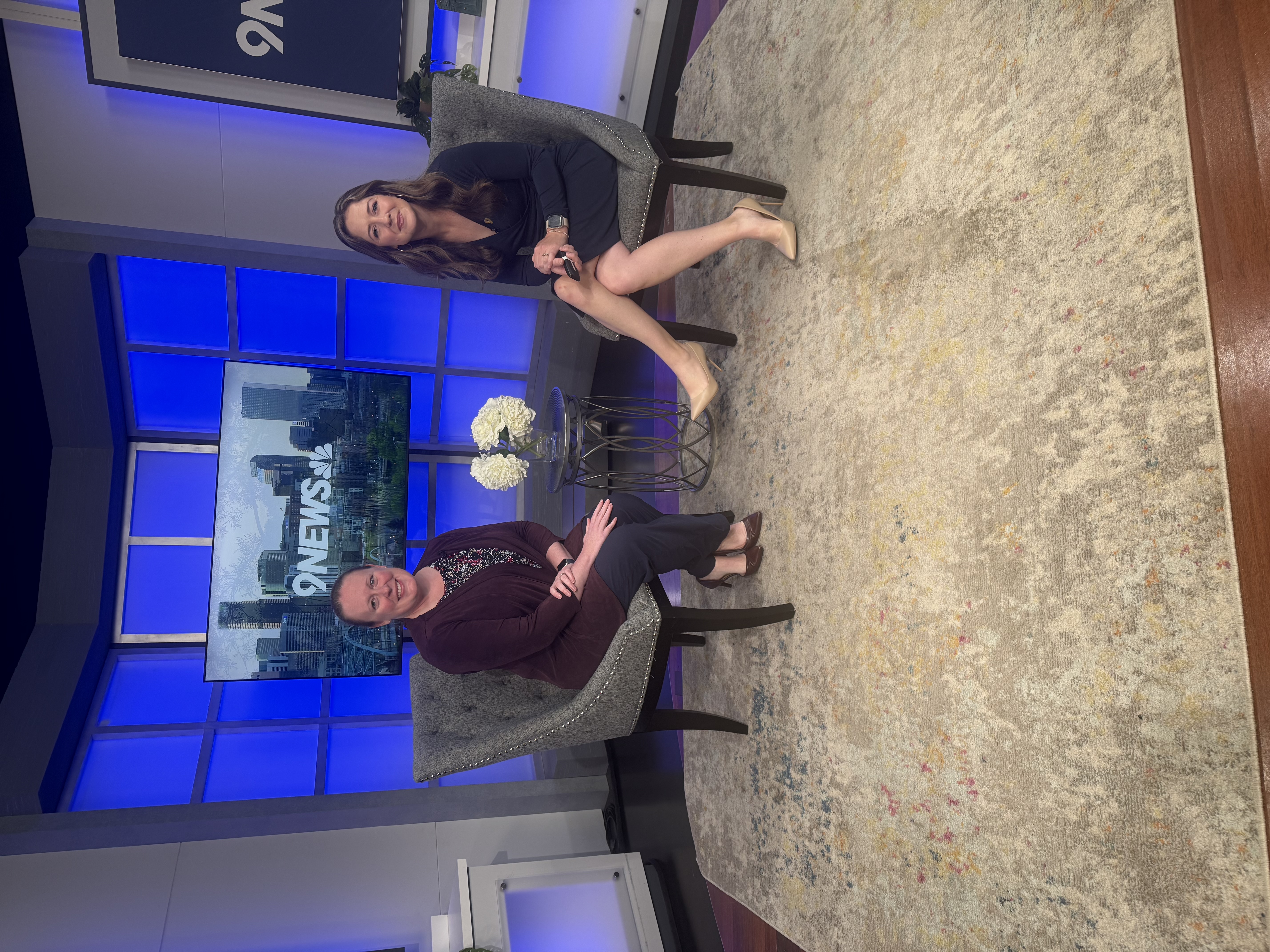 A pharmacist and news anchor seated in chairs in a television studio