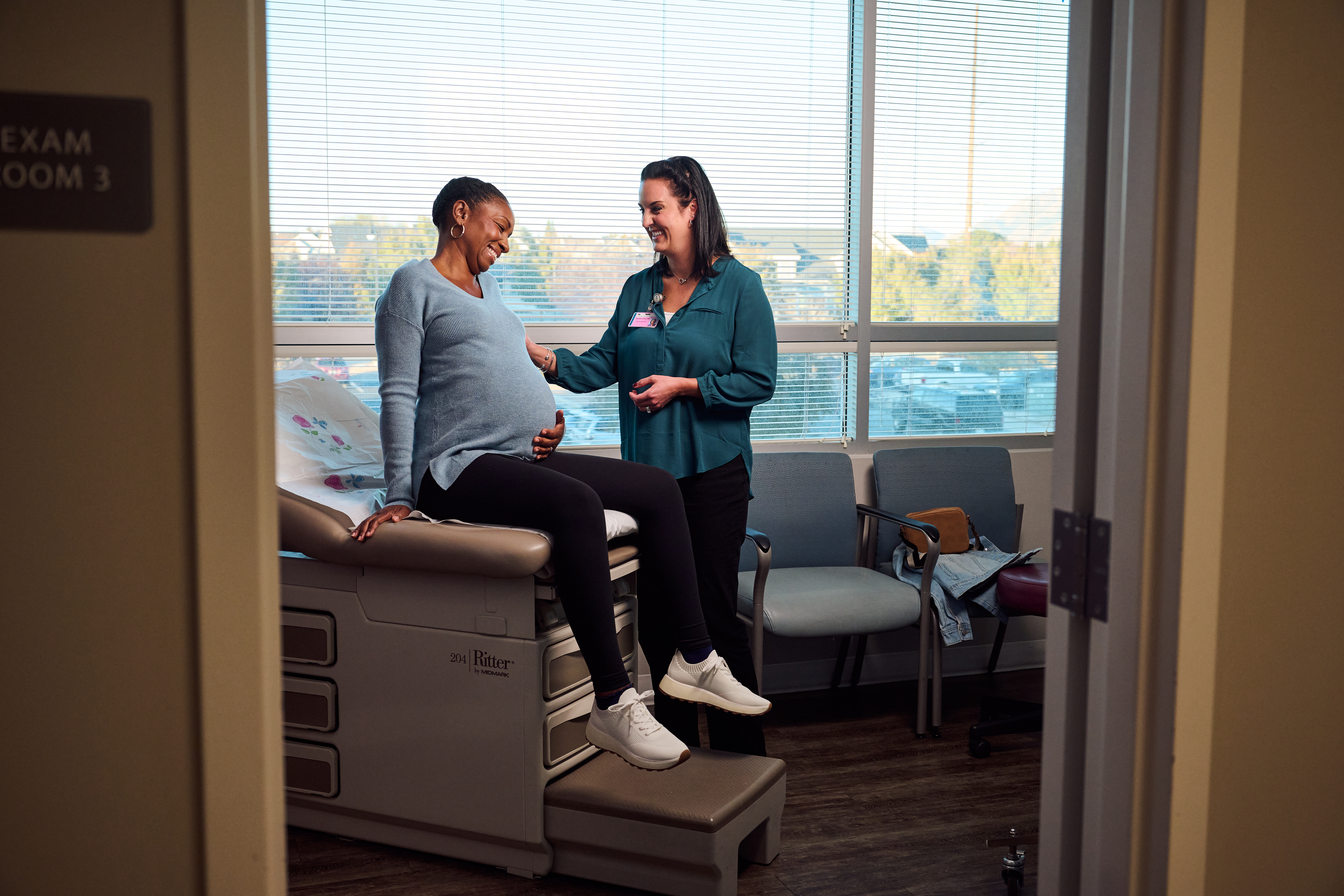 Pregnant patient with doctor in Lone Peak OBGYN exam room.