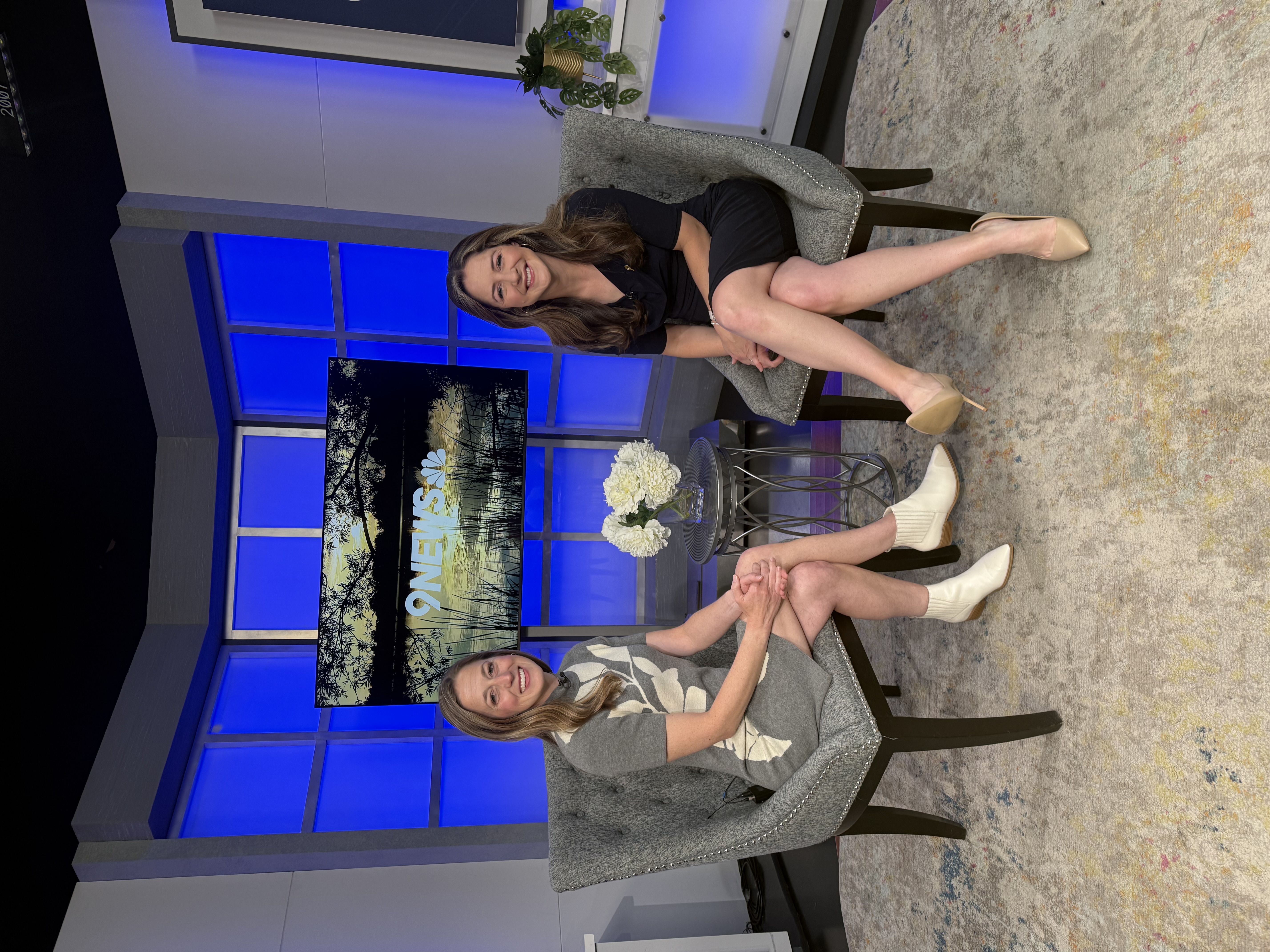 Dr. Abby Barnes with the 9News host, smiling for a picture on the 9News set.