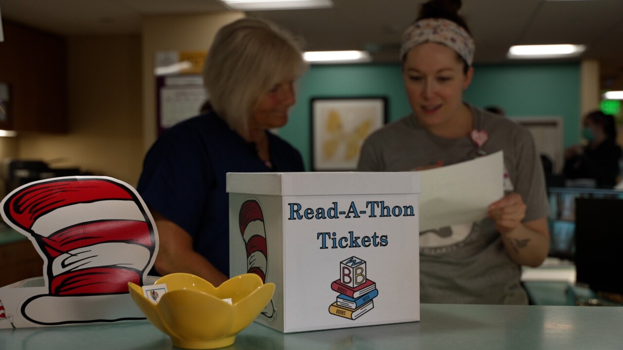 People reading next to a box that says "Read-a-thon tickets"