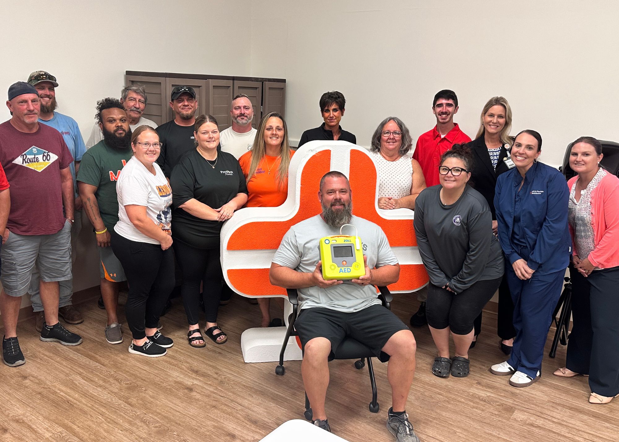 Coaches, parents and board members from the Englewood Area Athletic Association gathered with new AED device