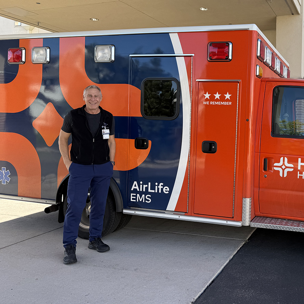 Rick Lindsey, on duty, standing in front of an HCA Healthcare ambulence.